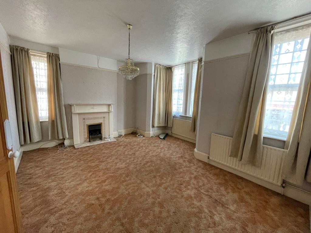 Lot: 144 - END-TERRACE PROPERTY ARRANGED AS THREE-BEDROOM HOUSE - Bedroom with bay window and fireplace